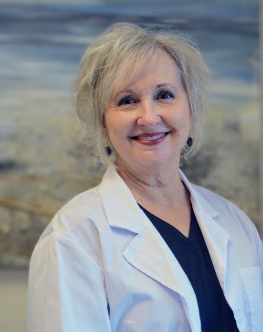 Senior clinician smiling warmly in white lab coat