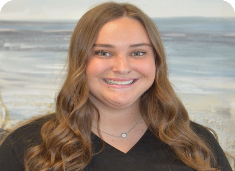 Smiling young woman with wavy brown hair and a black top.